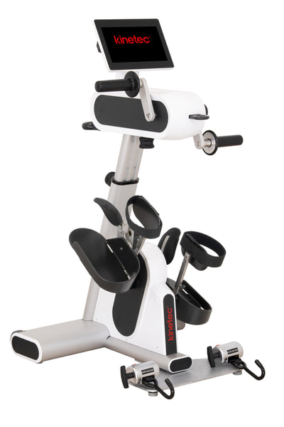 A Kinetec indoor exercise bike with a white and black frame, featuring a digital display screen, handlebars, foot pedals, and a mounting base on a plain white background.